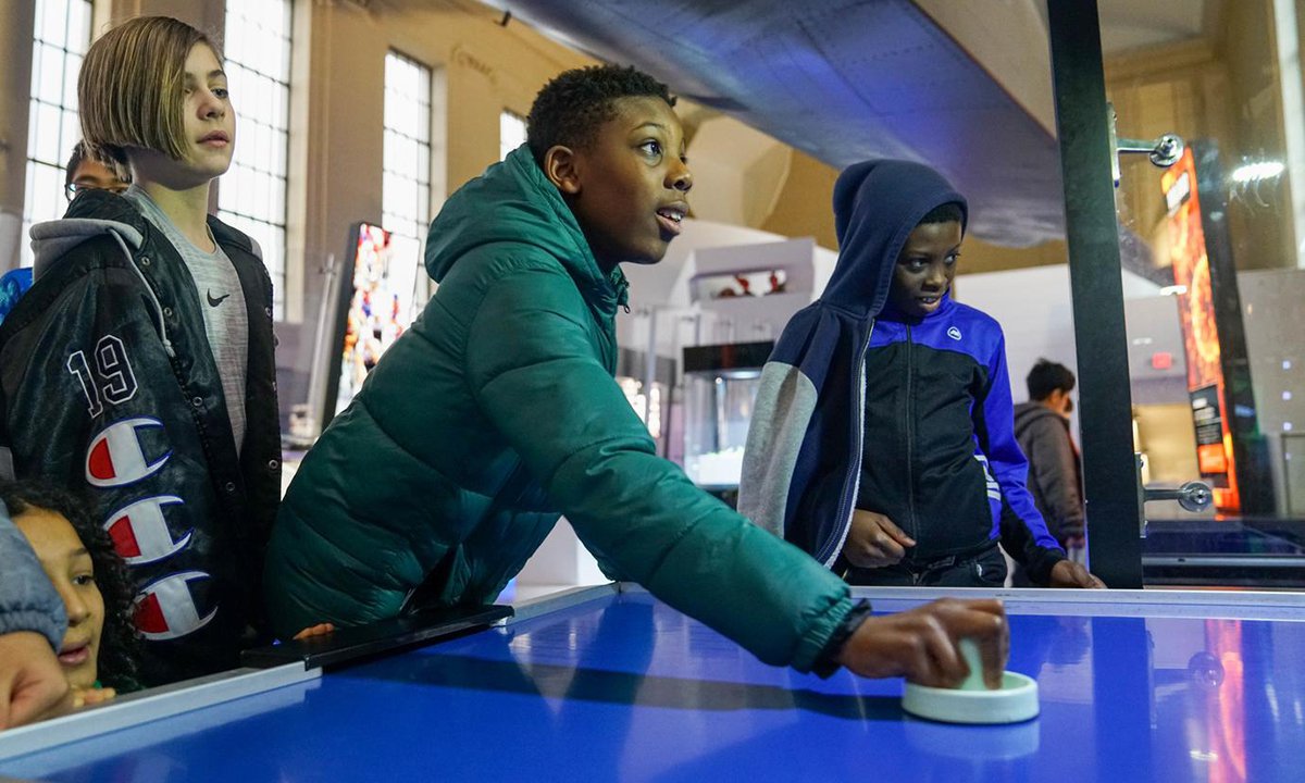 Guests playing air hockey against a robot.