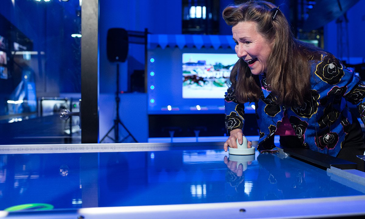 A guest playing air hockey against a robot when the Speed exhibition first opened.