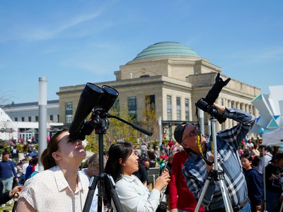 Community members viewing the solar eclipse through telescopes on the Green at the Science Museum of VirginiaJPG